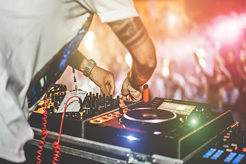 A stock photo of a zoomed in view of a DJ's turntables.