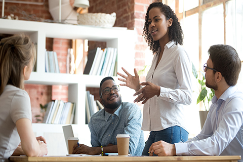 A stock photo of a woman leading a group meeting.